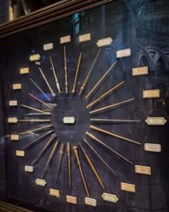 A display case containing a collection of wands arranged in a circular pattern, each labeled with a name tag.