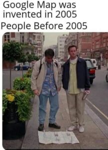 Joey and Chandler from Friends standing on a sidewalk looking down at a large paper map spread out on the ground showing how easy travel was back in the days. The text above them reads, "Google Map was invented in 2005. People Before 2005."