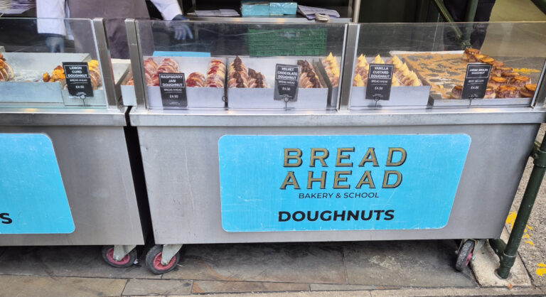 Display of various doughnuts from Bread Ahead Bakery & School, each labeled with their name and price.