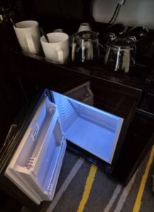 Mini-fridge with a blue interior light, ready to store any drinks chilled.