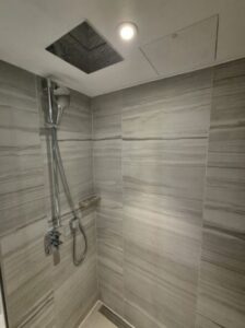 Spacious shower area with a modern rainfall showerhead.