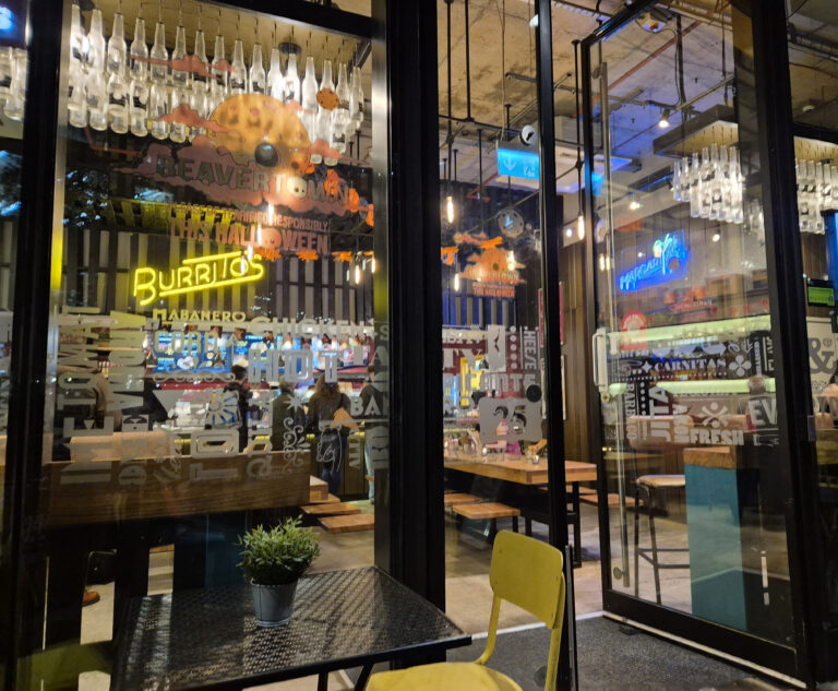 Entrance to Tortilla at Pancras Square, King's Cross, showing the restaurant's glass doors and neon signs inside.