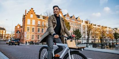 A person travelling on a bike in a city environment, a sustainable way to travel.