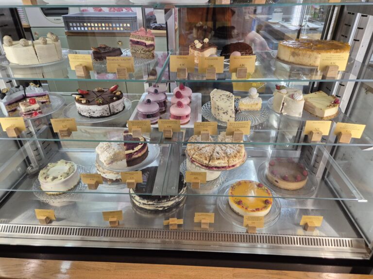 Display case in a Tallinn cafe filled with various cakes and pastries.