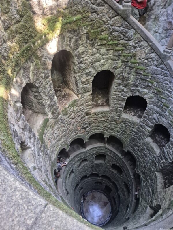 Spiral staircase inside the Initiation Well at Quinta da Regaleira, viewed from the bottom looking up.