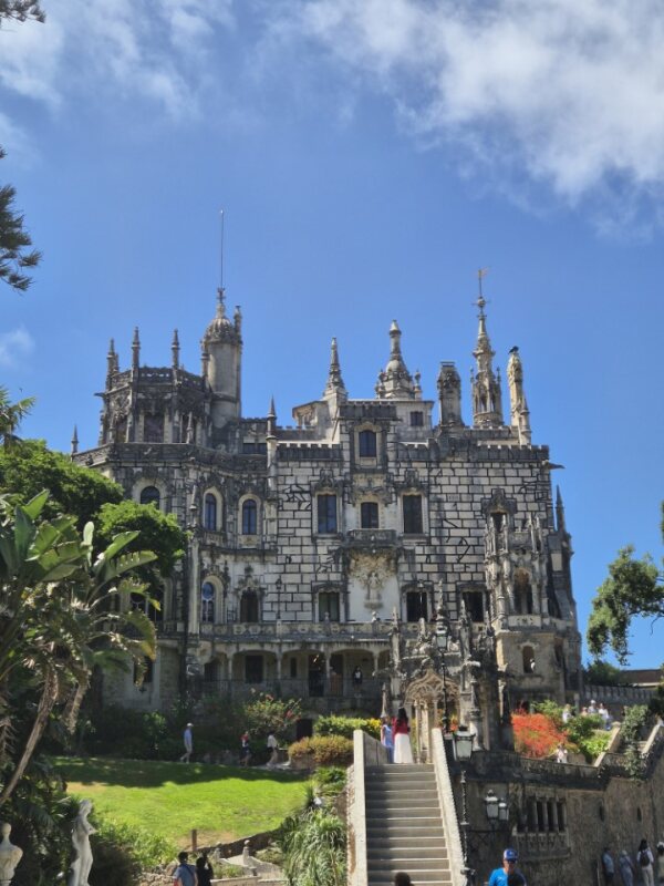 Gothic-style palace at Quinta da Regaleira with spires, intricate stone carvings, and surrounding greenery.