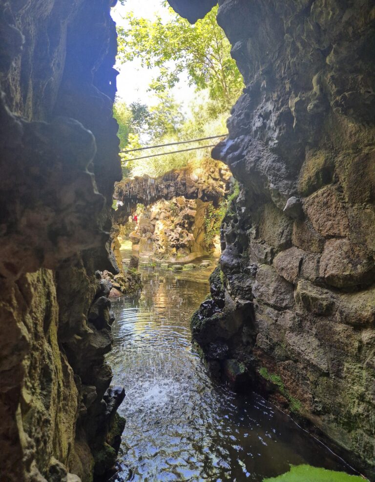Rocky garden passage with flowing water and surrounding vegetation at Quinta da Regaleira.