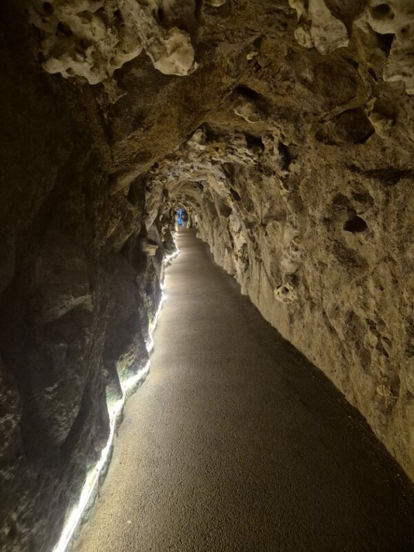 Narrow stone tunnel beneath Quinta da Regaleira, dimly lit and mysterious.