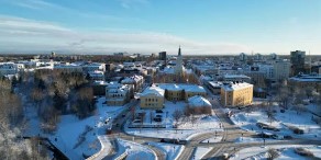 A winter look on the city of Oulu with snow on the ground and on top of buildings.