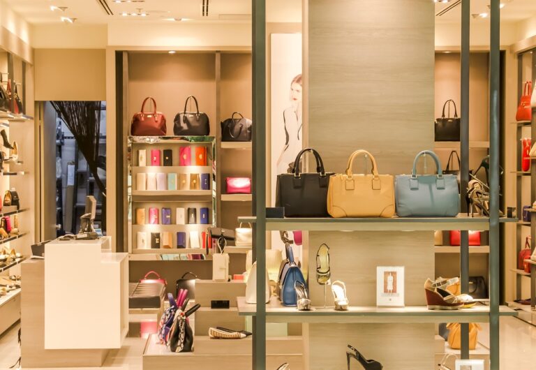 Interior of a high-end retail store displaying handbags and shoes under modern lighting.