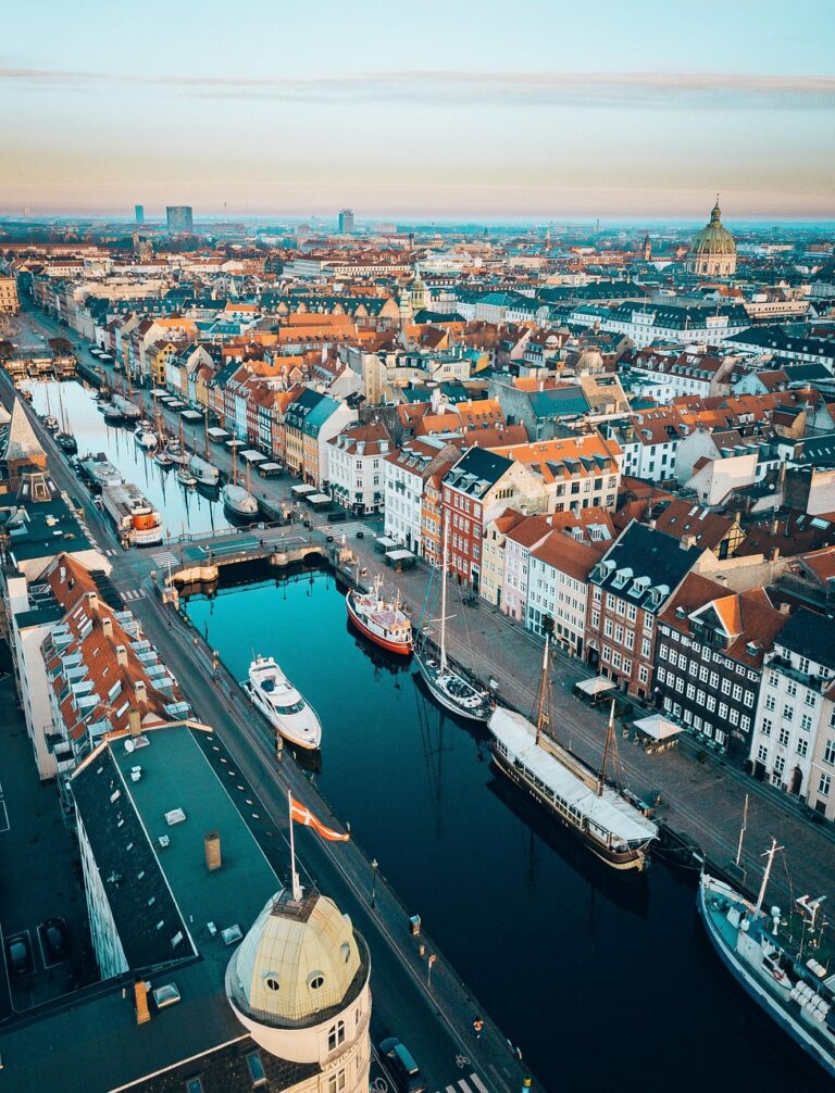 Aerial view of Nyhavn canal in Copenhagen lined with colorful buildings and boats.
