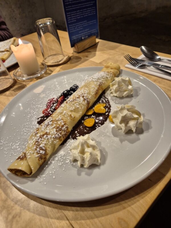 Sweet pancake with whipped cream and berries at Pirmas Blynas café
