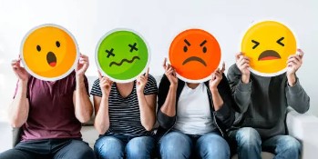 People holding emoji faces representing mixed experiences and opinions, illustrating what to know before working with Professio Group.